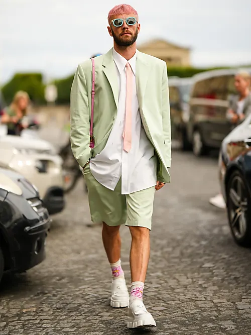 Influencer Karb trägt einen Grünen Anzug mit pinken Haaren auf der Paris Fashion Week